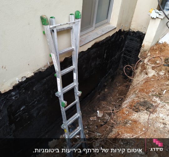 קיר אטום בזפת עם סולם מתכת צמוד